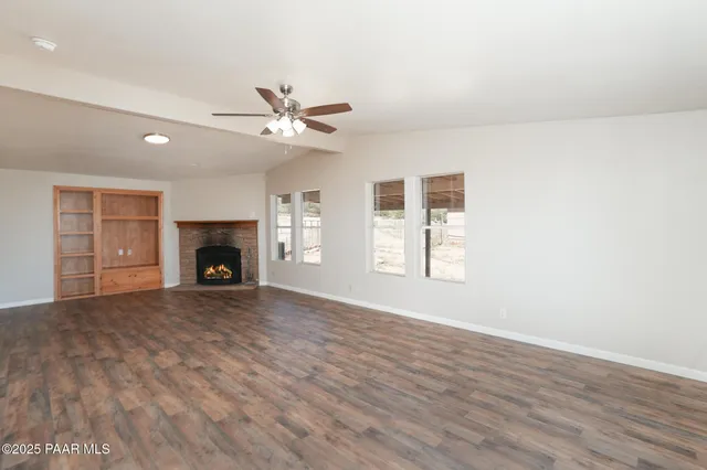 a view of a livingroom with wooden floor and a fireplace