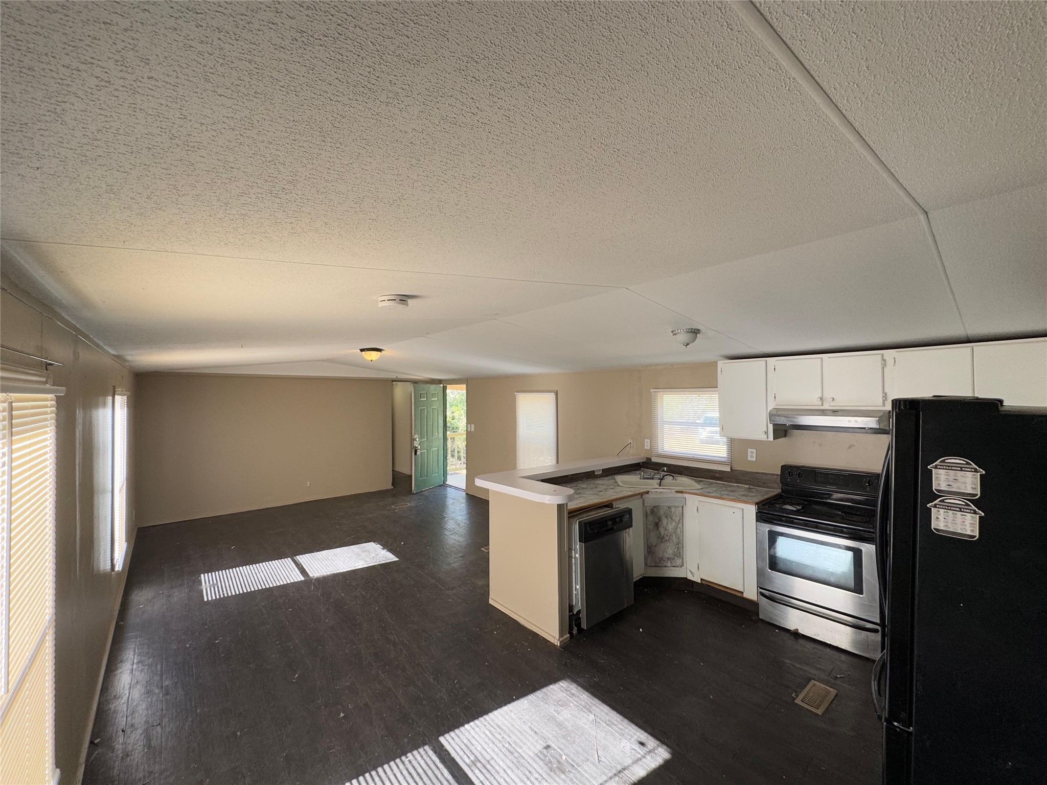 8315 Burleson Manor Road, Unit B Manor, TX 78653 - Photo 14 of 15 a kitchen with granite countertop stainless steel appliances and white cabinets