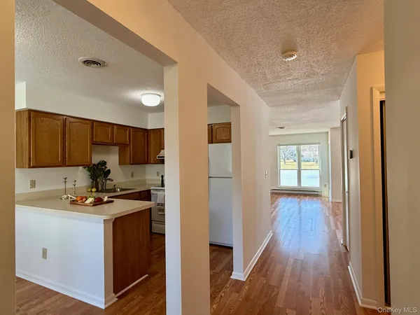 a view of a kitchen with a sink and dishwasher a refrigerator with wooden floor