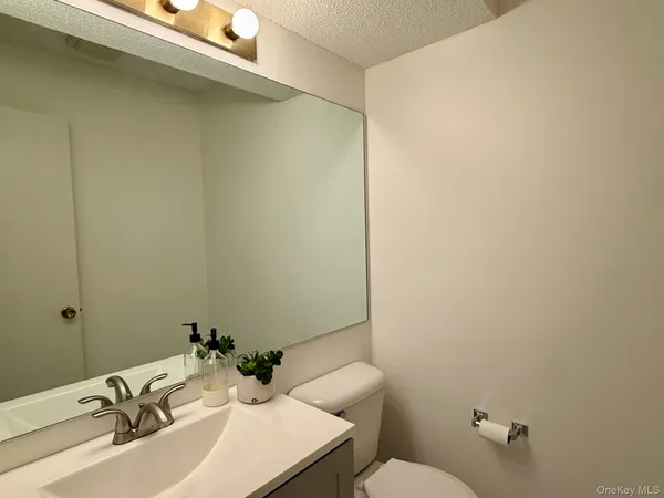 a bathroom with a sink mirror and toilet