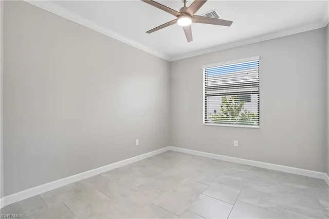 an empty room with a window and a fan