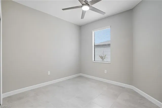 an empty room with a window and a fan