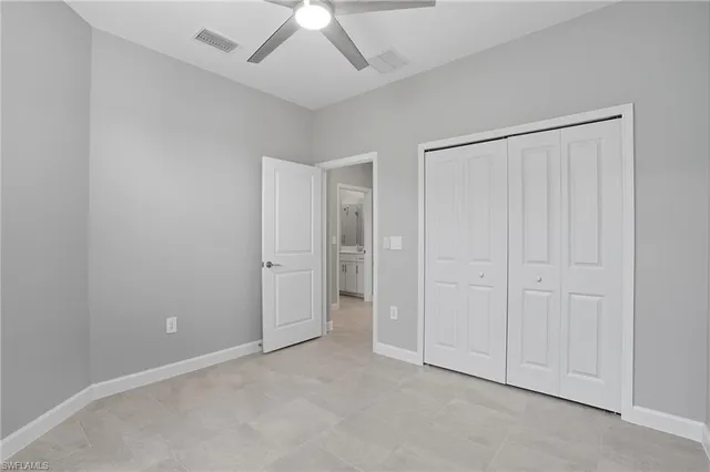 an empty room with a ceiling fan and entryway