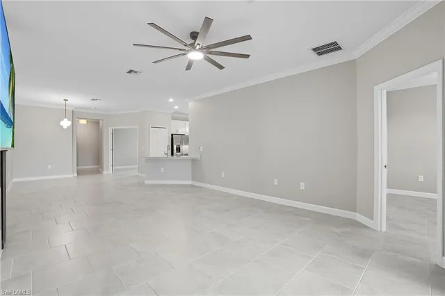 an empty room with fan and windows