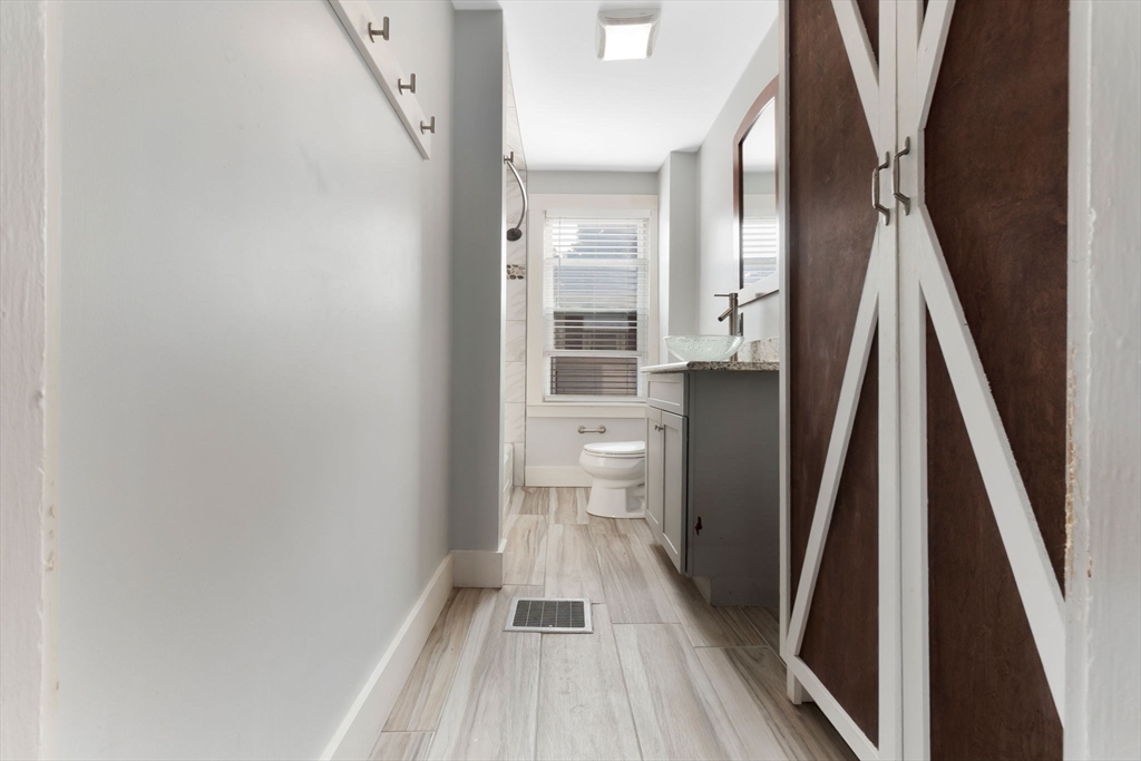 21 Goodell Street, Unit 1 Salem, MA 01970 - Photo 11 of 19 a view of a hallway with wooden floor and a bathroom