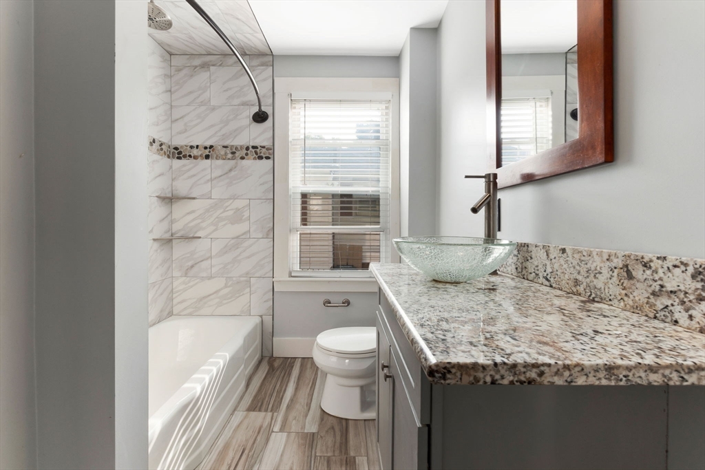 21 Goodell Street, Unit 1 Salem, MA 01970 - Photo 12 of 19 a bathroom with a granite countertop sink toilet and shower