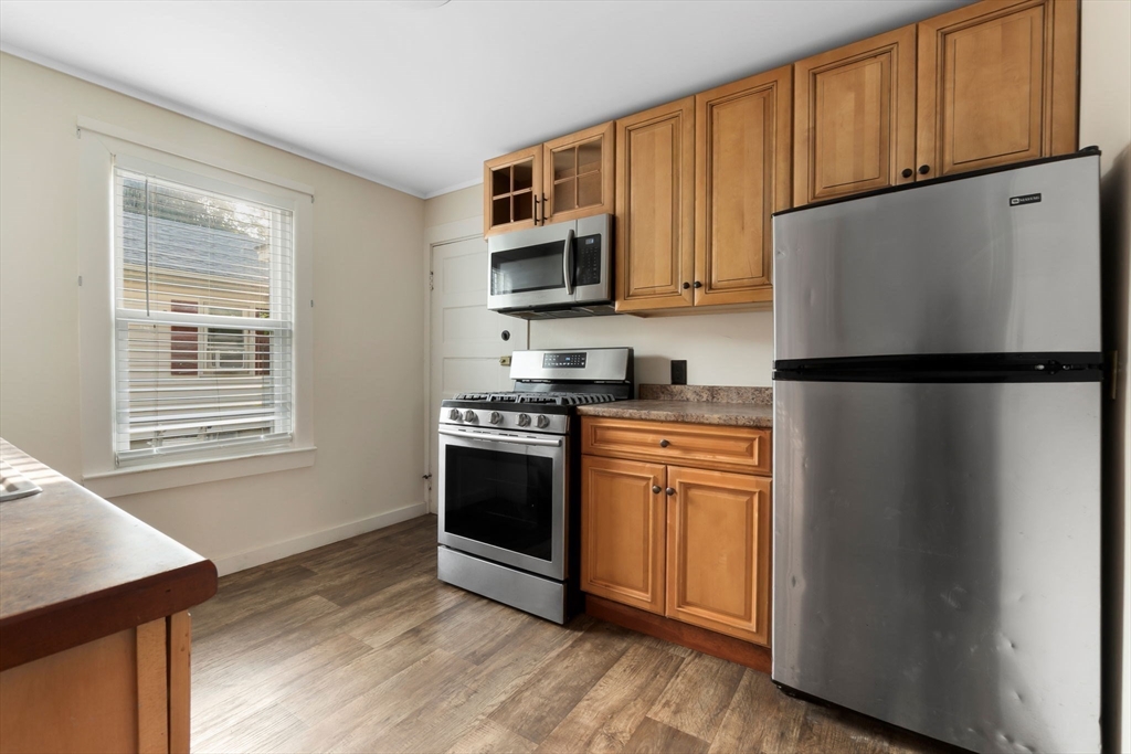 21 Goodell Street, Unit 1 Salem, MA 01970 - Photo 3 of 19 a kitchen with stainless steel appliances granite countertop a refrigerator stove a sink dishwasher and microwave