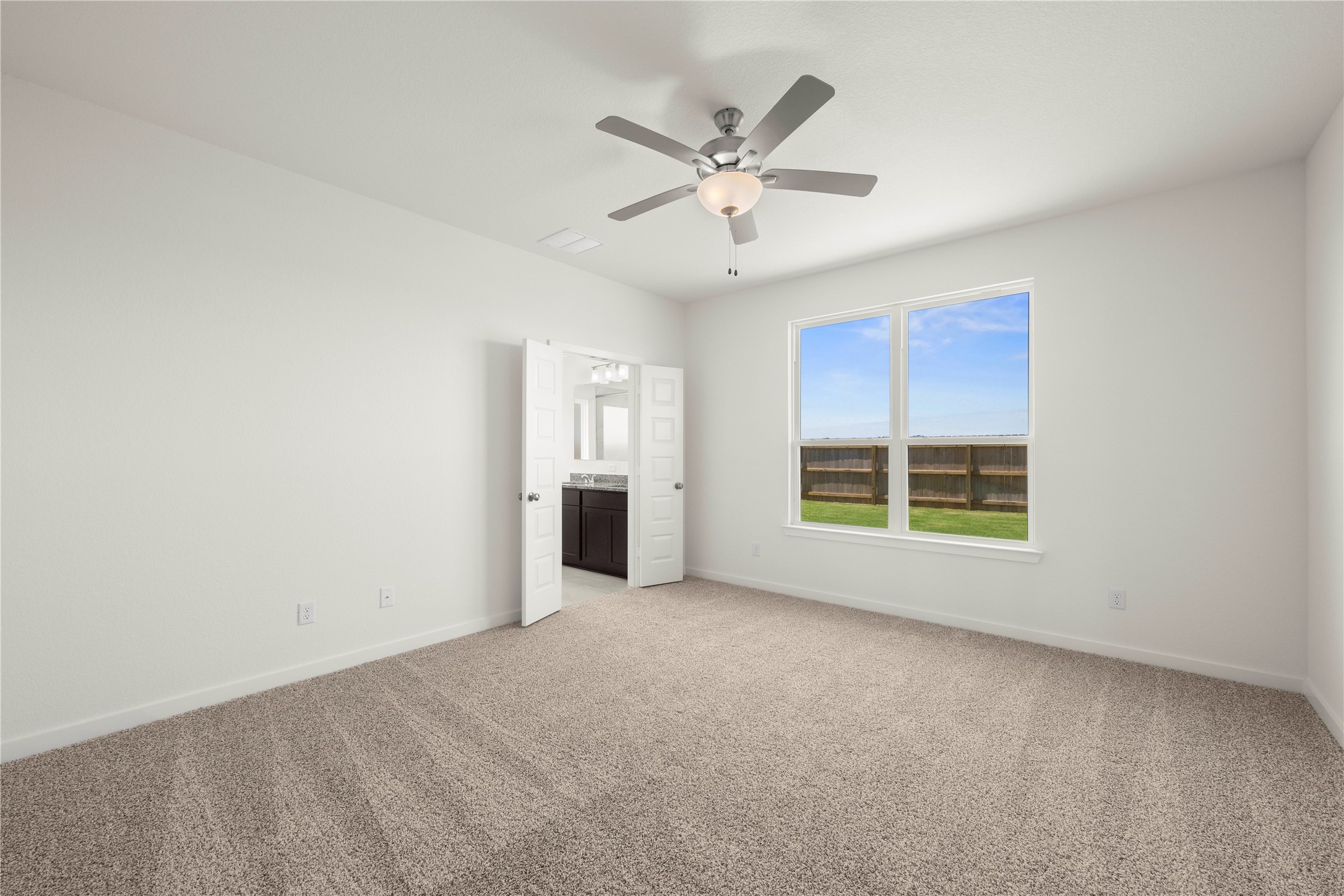 228 Gus Loop Georgetown, TX 78626 - Photo 8 of 19 A spacious primary bedroom with a large window and convenient access to an en-suite bathroom.