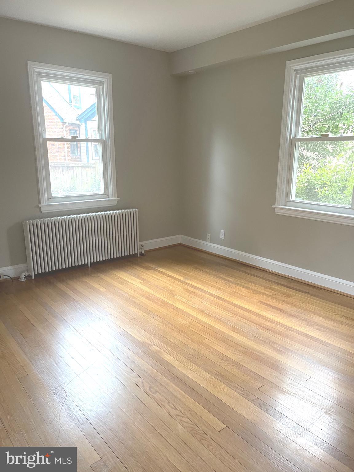 9803 Forest Grove Drive Silver Spring, MD 20902 - Photo 15 of 24 a view of an empty room with wooden floor and a window