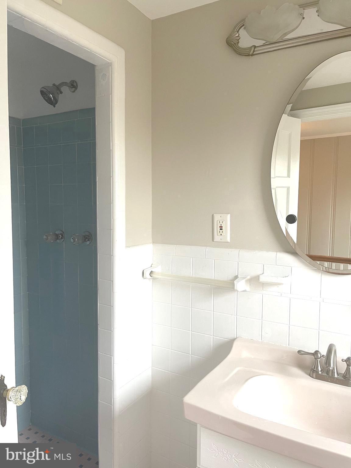 9803 Forest Grove Drive Silver Spring, MD 20902 - Photo 17 of 24 a bathroom with a sink and a mirror