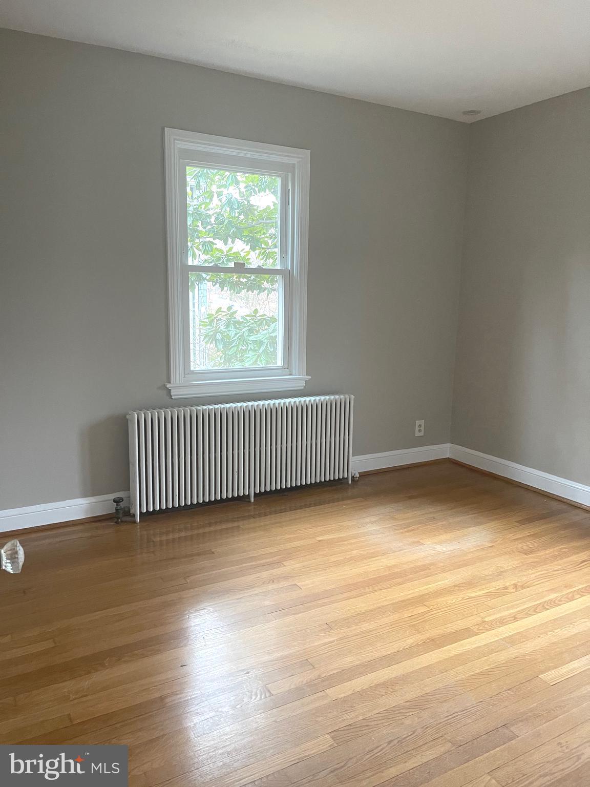 9803 Forest Grove Drive Silver Spring, MD 20902 - Photo 18 of 24 an empty room with wooden floor and windows