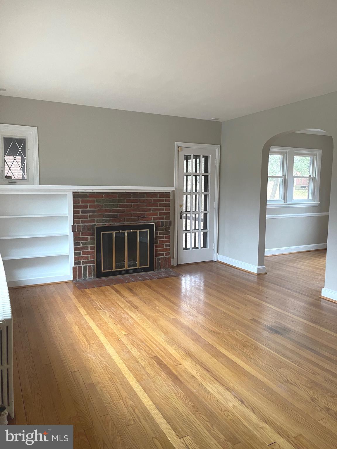 9803 Forest Grove Drive Silver Spring, MD 20902 - Photo 4 of 24 an empty room with windows and fireplace
