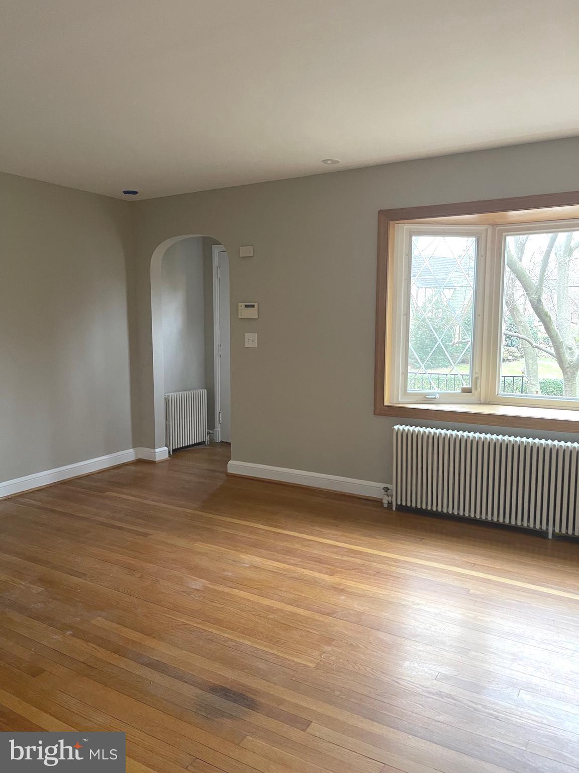 9803 Forest Grove Drive Silver Spring, MD 20902 - Photo 6 of 24 a view of an empty room with wooden floor and a window