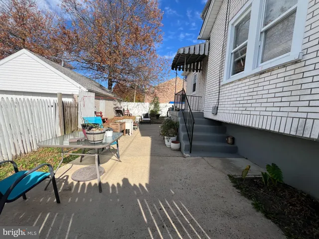 a view of a patio with table and chairs with wooden floor and fence