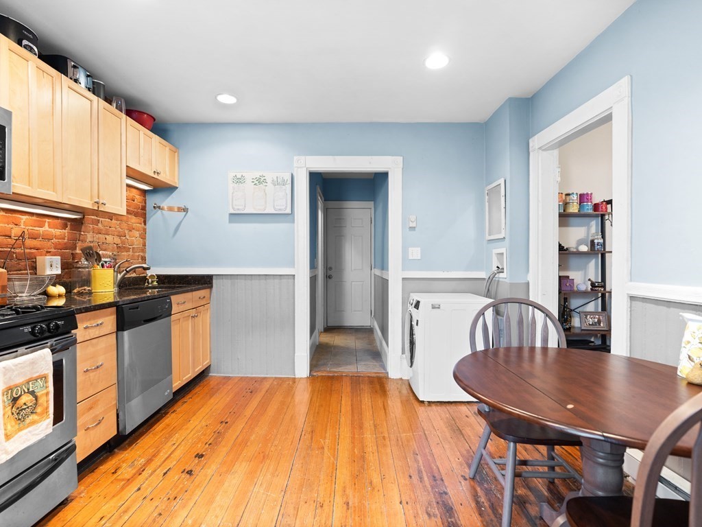 427-435 Faneuil Street, Unit R4 Boston, MA 02135 - Photo 8 of 18 a kitchen with stainless steel appliances granite countertop a stove a sink a dining table and chairs