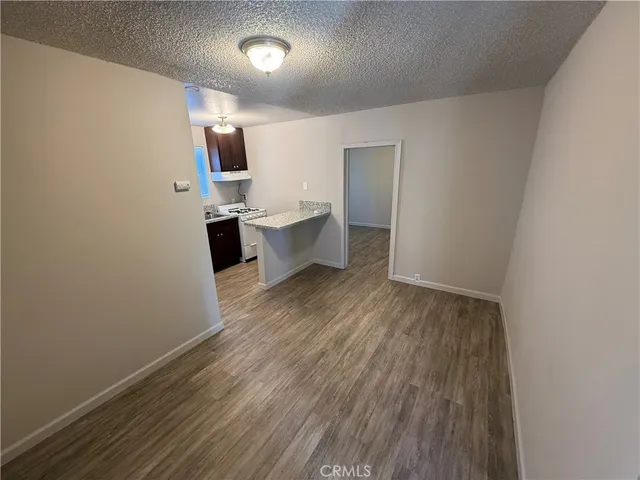 a view of a kitchen with wooden floor and electronic appliances