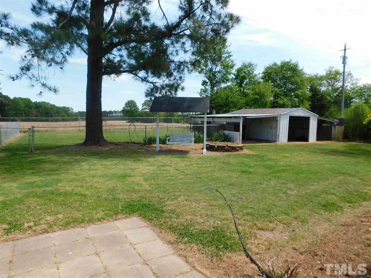 12638 Old Raleigh-Wilson Road Middlesex, NC 27557 - Photo 22 of 23 a backyard of a house with table and chairs next to a yard