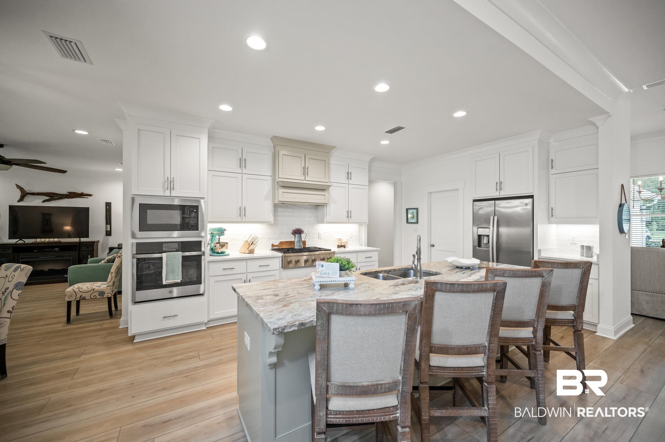 4601 Surrey Lane Orange Beach, AL 36561 - Photo 14 of 43 Kitchen featuring appliances with stainless steel finishes, light hardwood / wood-style floors, sink, a breakfast bar area, and ceiling fan