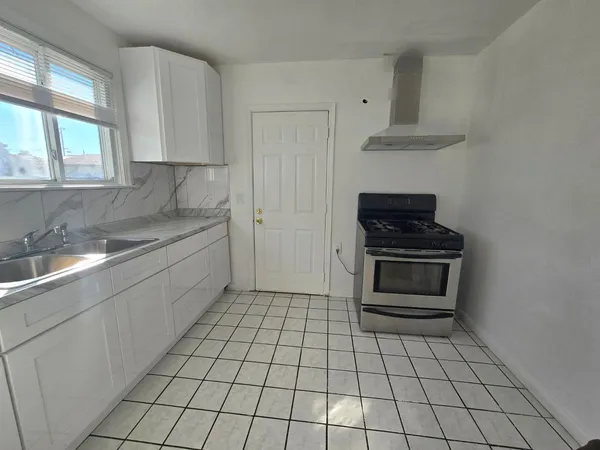 a kitchen with a sink a stove and cabinets