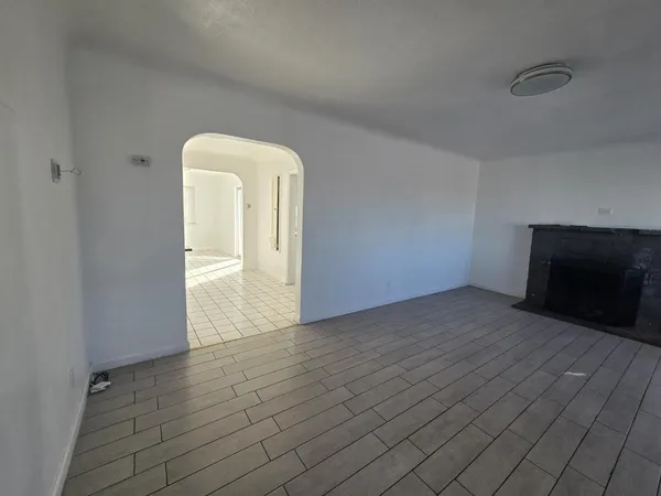 a view of a livingroom with wooden floor and a fireplace