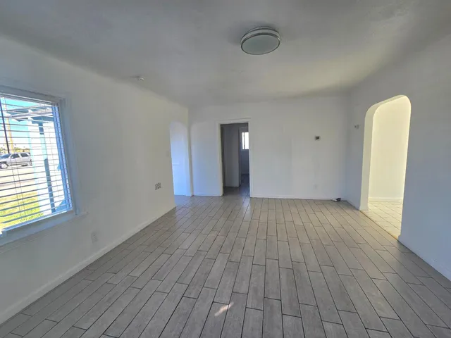 a view of a room with wooden floor and a window