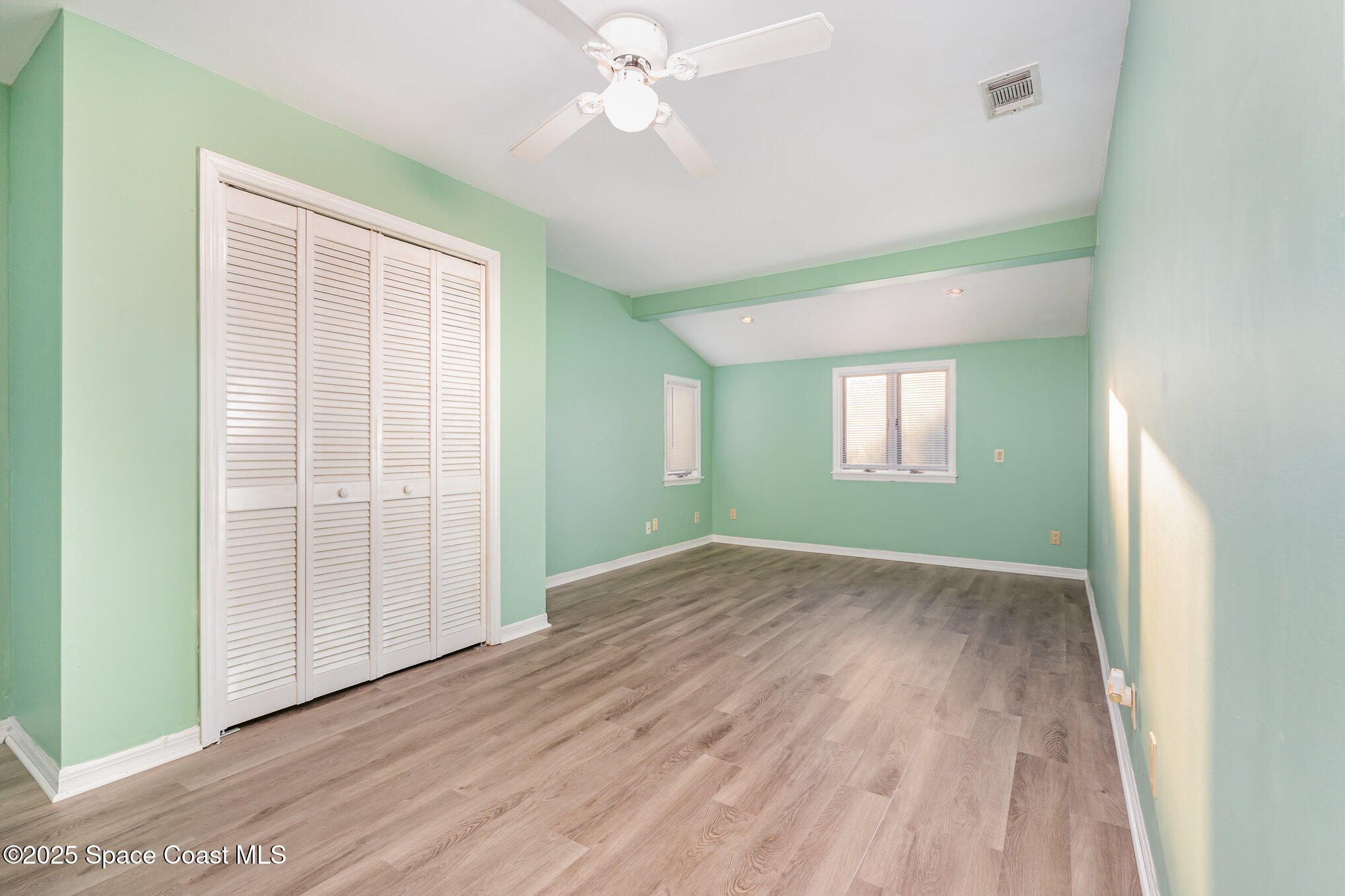 2155 Palm Avenue Indialantic, FL 32903 - Photo 7 of 15 an empty room with wooden floor closet and windows