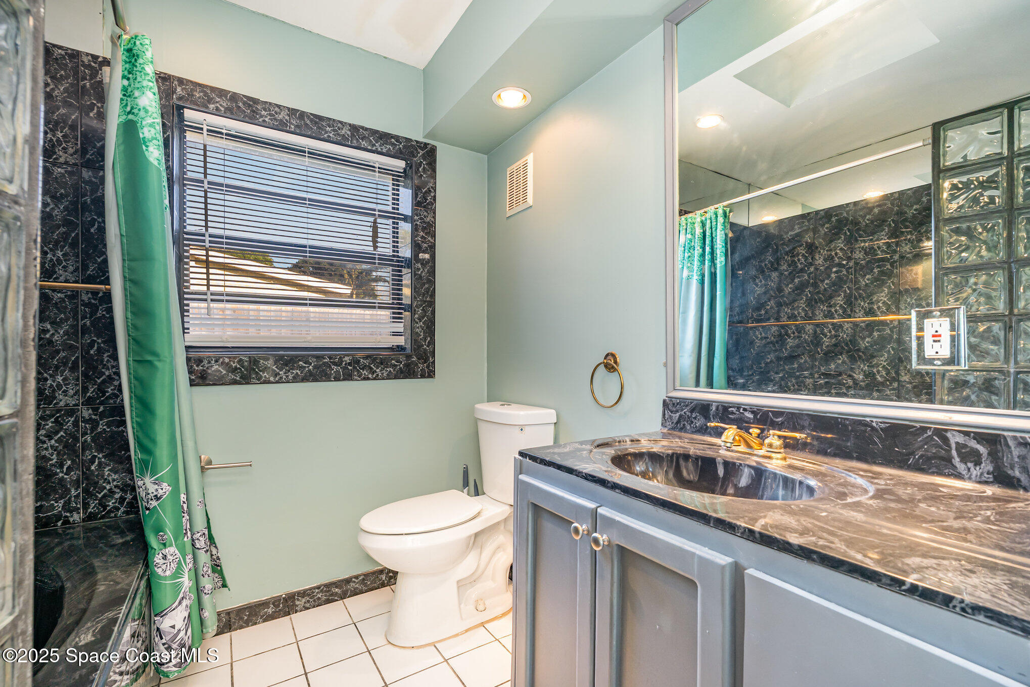 2155 Palm Avenue Indialantic, FL 32903 - Photo 10 of 15 a bathroom with a sink a toilet and a window