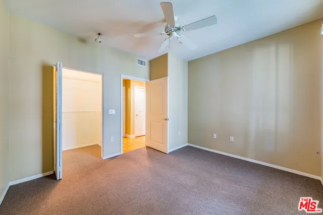 a view of an empty room and a ceiling fan window