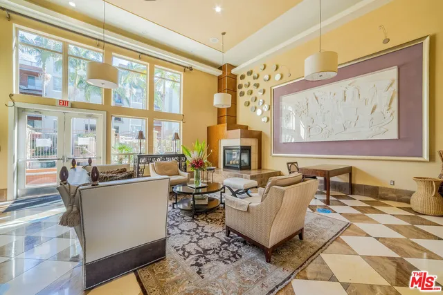 a living room with furniture large windows and a fireplace
