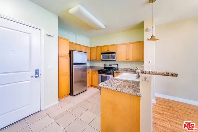 a kitchen with stainless steel appliances granite countertop a refrigerator and a stove top oven