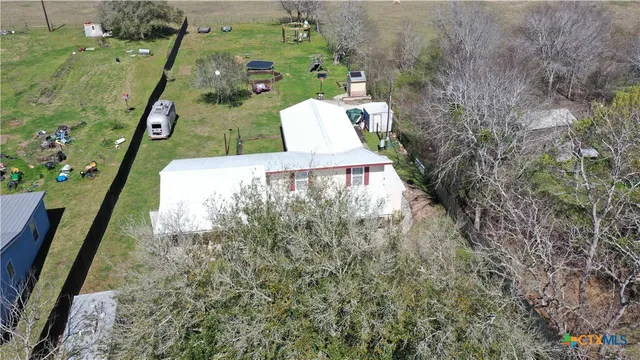 an aerial view of a house with swimming pool and mountains