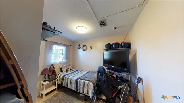 a bedroom with a bed and a flat screen tv
