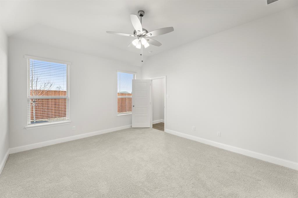 125 Meadow Road Balch Springs, TX 75181 - Photo 18 of 27 an empty room with chandelier fan and windows