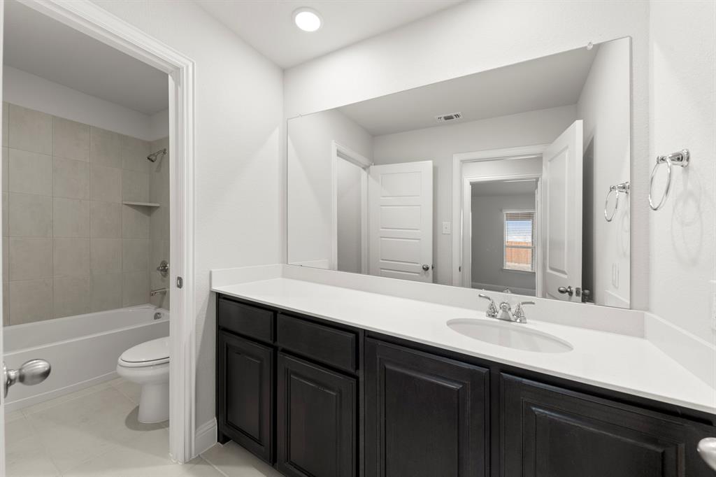 125 Meadow Road Balch Springs, TX 75181 - Photo 22 of 27 a bathroom with a double vanity sink toilet mirror and bathtub