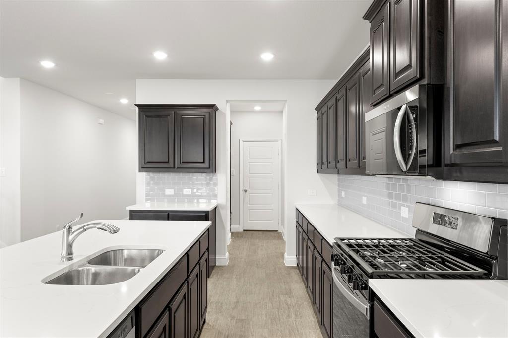 125 Meadow Road Balch Springs, TX 75181 - Photo 4 of 27 a kitchen that has a sink and stainless steel appliances