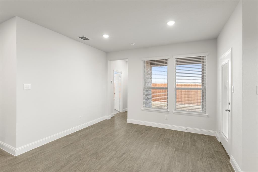 125 Meadow Road Balch Springs, TX 75181 - Photo 10 of 27 an empty room with wooden floor and windows