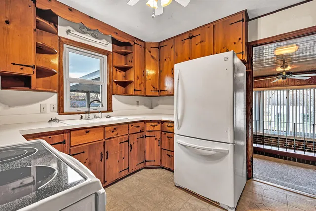 a white refrigerator freezer and a stove sitting inside of a kitchen