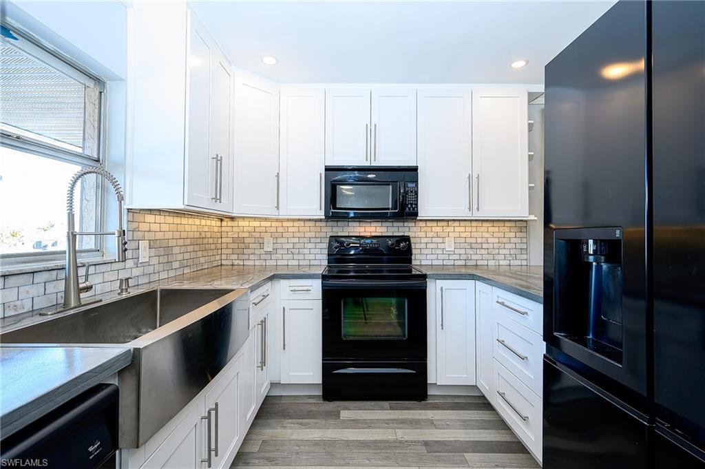 5499 Rattlesnake Hammock Road, Unit 304A Naples, FL 34113 - Photo 11 of 38 a kitchen with stainless steel appliances granite countertop a stove a sink and a microwave