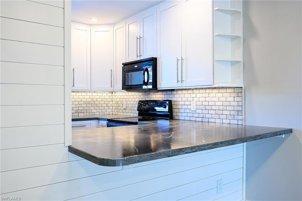5499 Rattlesnake Hammock Road, Unit 304A Naples, FL 34113 - Photo 13 of 38 a view of kitchen sink microwave and cabinets