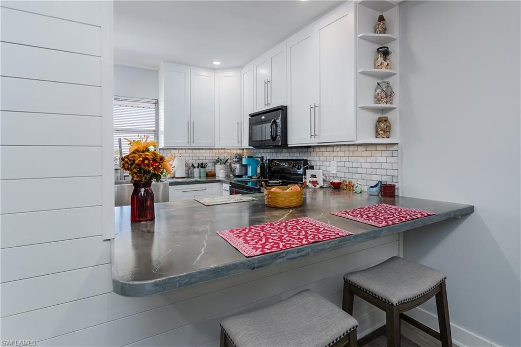 5499 Rattlesnake Hammock Road, Unit 304A Naples, FL 34113 - Photo 14 of 38 a kitchen with a stove a faucet and cabinetry