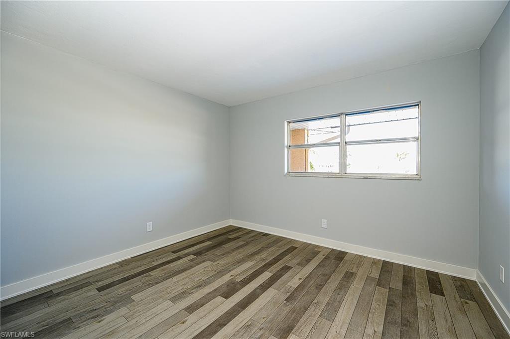 5499 Rattlesnake Hammock Road, Unit 304A Naples, FL 34113 - Photo 23 of 38 wooden floor in an empty room with a window