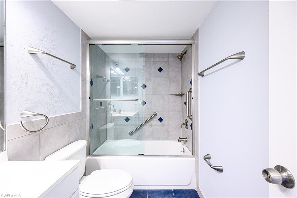 5499 Rattlesnake Hammock Road, Unit 304A Naples, FL 34113 - Photo 25 of 38 a bathroom with a granite countertop bathtub shower sink vanity and toilet
