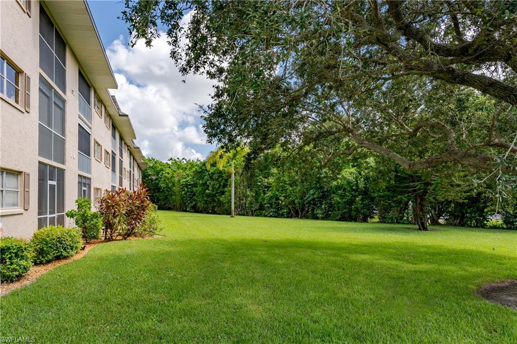 5499 Rattlesnake Hammock Road, Unit 304A Naples, FL 34113 - Photo 29 of 38 a view of a big yard with plants and large trees