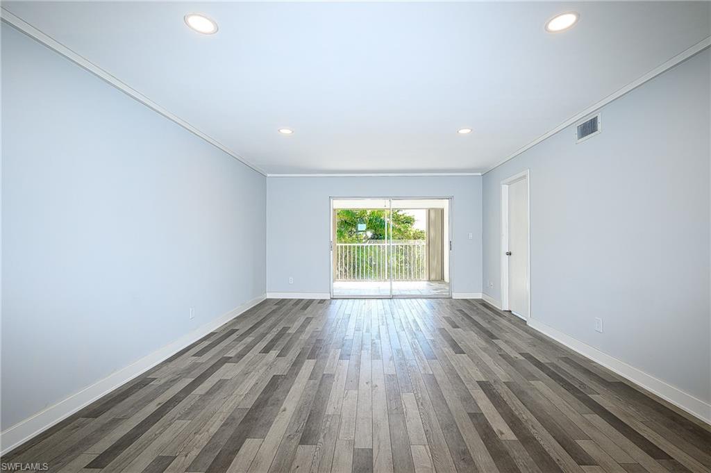 5499 Rattlesnake Hammock Road, Unit 304A Naples, FL 34113 - Photo 10 of 38 a view of an empty room with wooden floor and a window