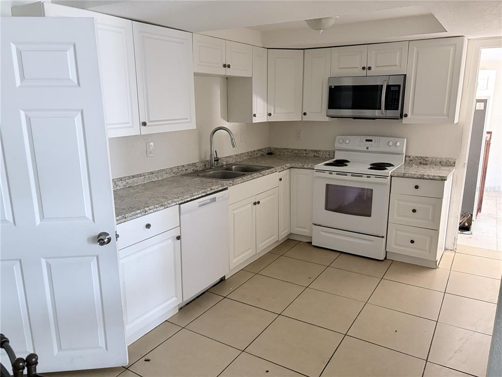 3818 Moog Road Holiday, FL 34691 - Photo 13 of 19 a kitchen with stainless steel appliances granite countertop a sink and a stove
