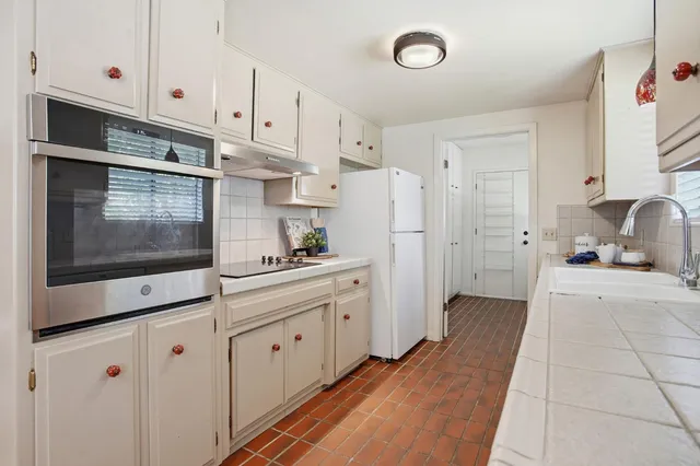 a kitchen with white cabinets and white appliances