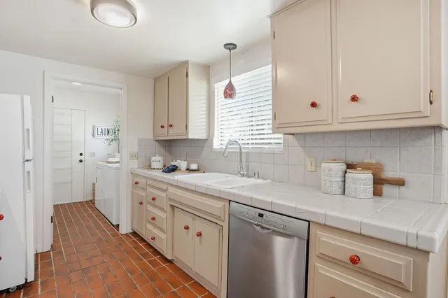 a kitchen with cabinets appliances a sink and a window