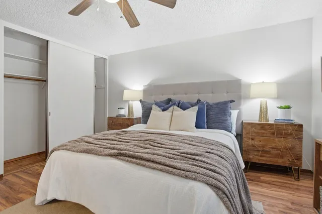 a bedroom with a bed a dresser and a chandelier