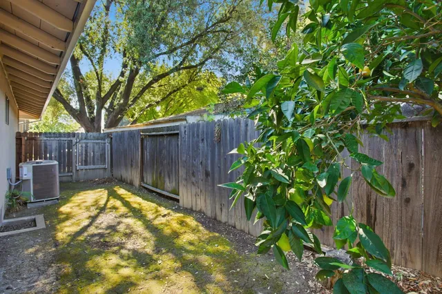 a view of a backyard with wooden fence and a fountain