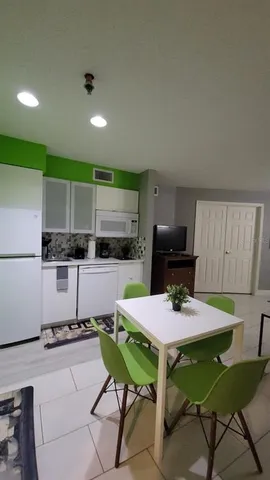 a kitchen with a table chairs stove and refrigerator